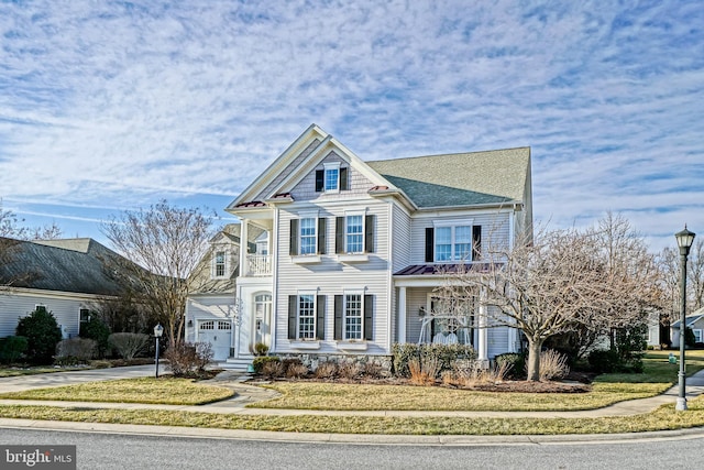 victorian-style house featuring a garage, concrete driveway, and a front lawn