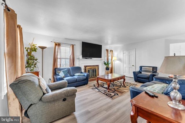 living area with light wood-style flooring and a fireplace