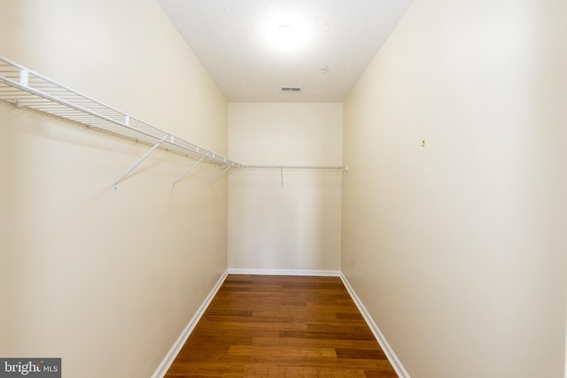 walk in closet featuring visible vents and wood finished floors