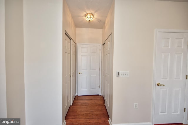 corridor with dark wood-type flooring and a textured ceiling