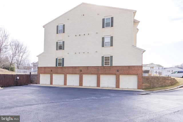 view of side of home with fence and brick siding