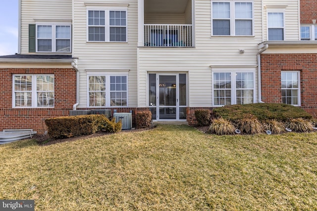 rear view of property featuring a yard and central AC unit