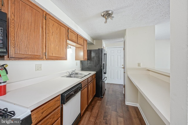 kitchen with dark wood finished floors, brown cabinetry, light countertops, black appliances, and a sink