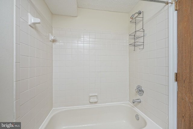 full bath featuring tub / shower combination and a textured ceiling