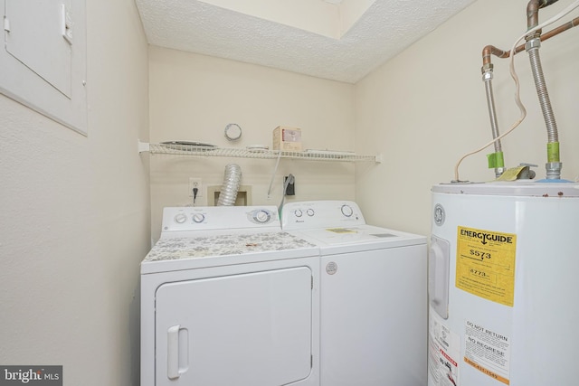 clothes washing area with water heater, laundry area, a textured ceiling, and independent washer and dryer