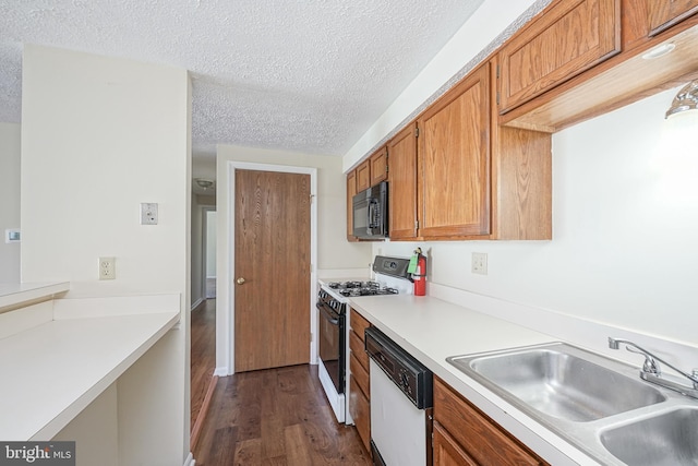 kitchen with white appliances, light countertops, a sink, and brown cabinetry