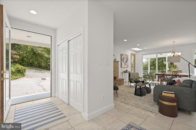 foyer featuring a chandelier, recessed lighting, light tile patterned flooring, and baseboards