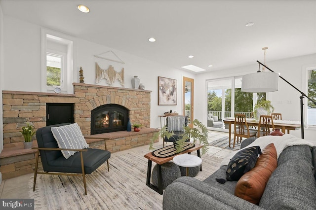 living area with a stone fireplace and recessed lighting