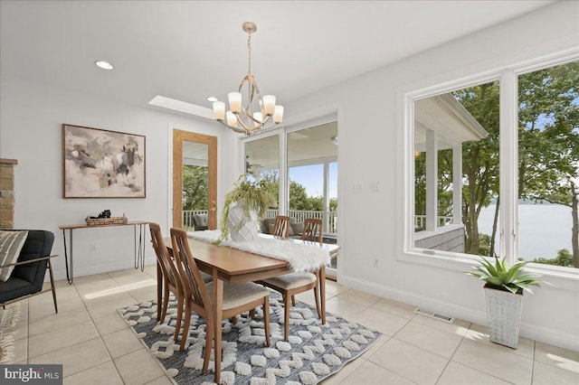 dining area with an inviting chandelier, light tile patterned floors, and baseboards