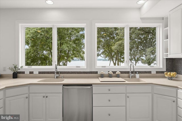 kitchen featuring white cabinets, light countertops, stainless steel dishwasher, a sink, and recessed lighting