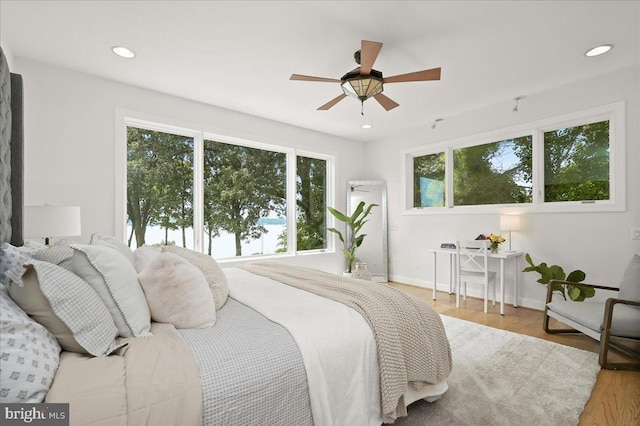 bedroom with multiple windows, wood finished floors, and recessed lighting