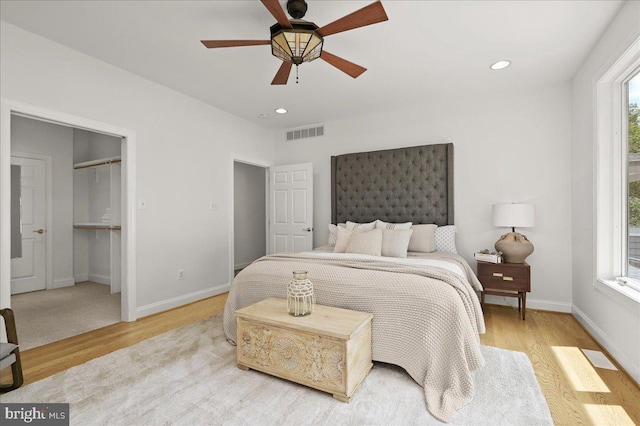 bedroom with multiple windows, wood finished floors, and visible vents