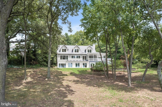 view of front facade featuring a sunroom and a chimney