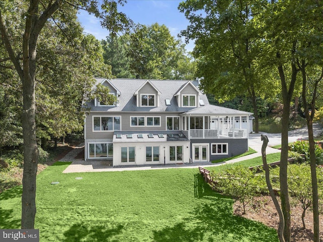 back of property featuring a yard and a balcony