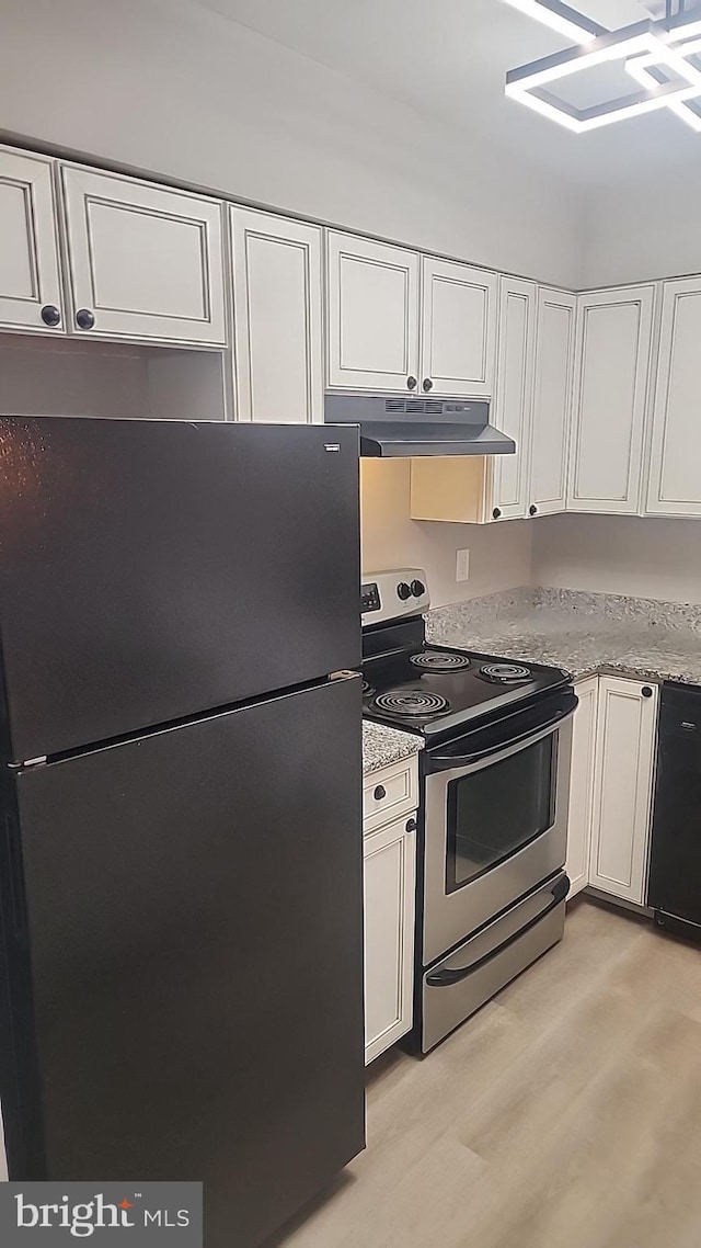 kitchen featuring electric stove, white cabinetry, freestanding refrigerator, and under cabinet range hood