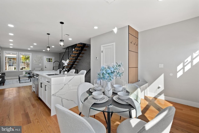 dining space featuring sink and light wood-type flooring