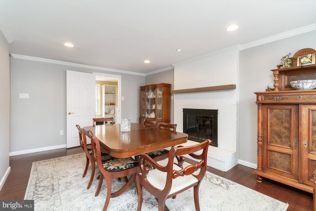 dining room with ornamental molding, a brick fireplace, and dark hardwood / wood-style flooring