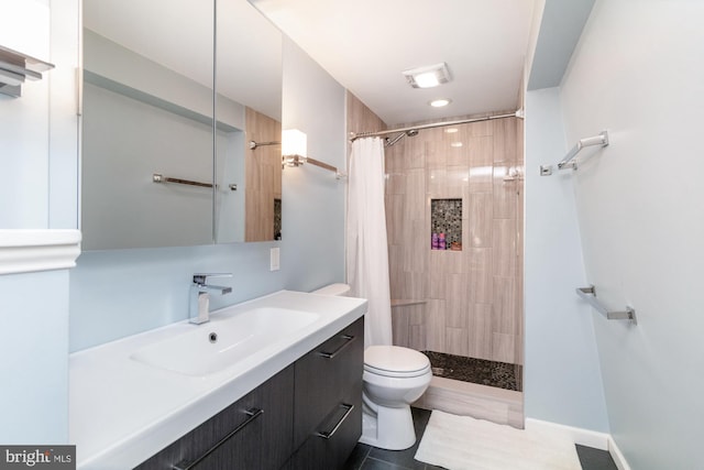 bathroom with tile patterned floors, toilet, vanity, and walk in shower