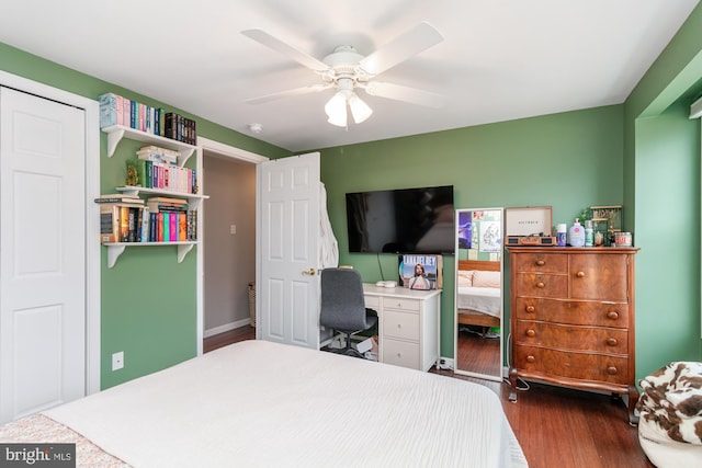 bedroom with dark hardwood / wood-style flooring and ceiling fan