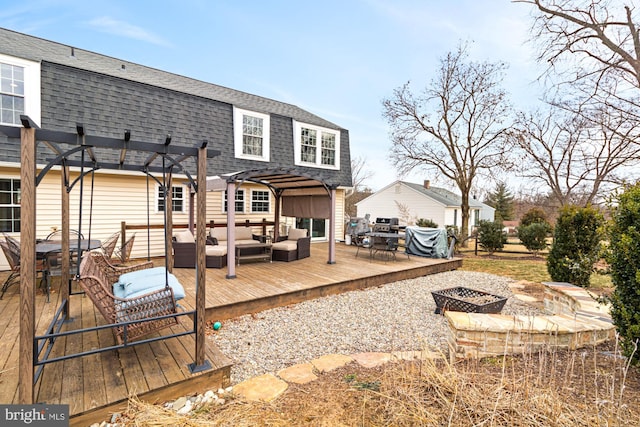 back of property with a deck, a pergola, and an outdoor living space with a fire pit