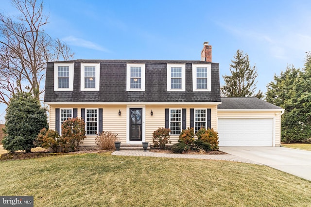 colonial inspired home with a garage and a front yard