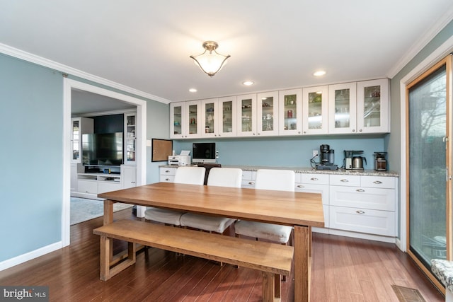 dining room featuring hardwood / wood-style floors and ornamental molding