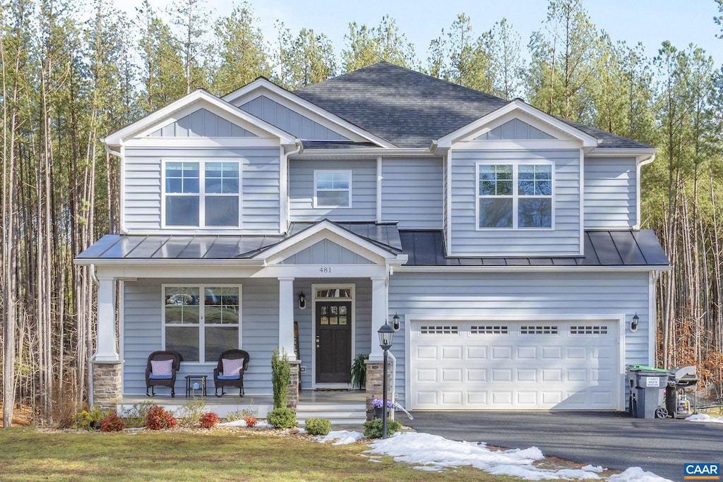 craftsman-style house with a garage, a front lawn, and covered porch