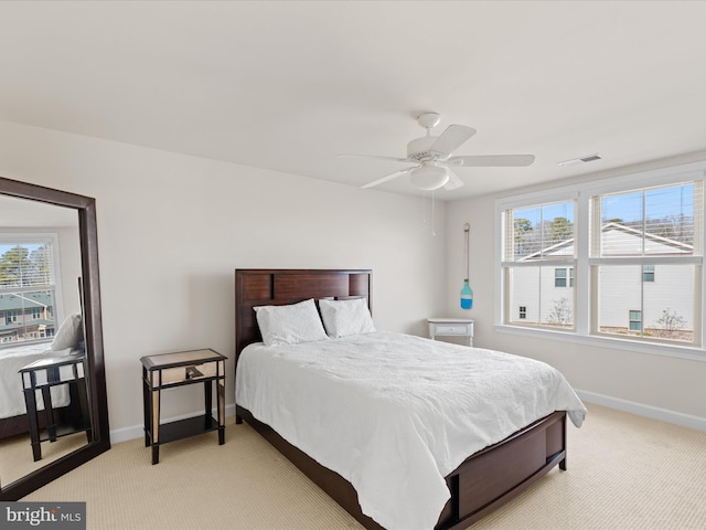 bedroom with baseboards, ceiling fan, visible vents, and light colored carpet