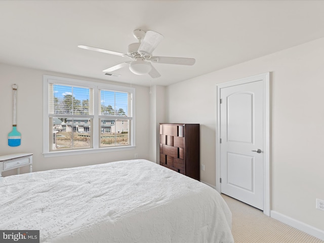 carpeted bedroom featuring baseboards, visible vents, and a ceiling fan