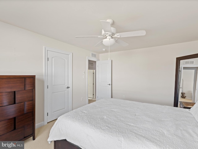 bedroom featuring a ceiling fan, visible vents, and light colored carpet