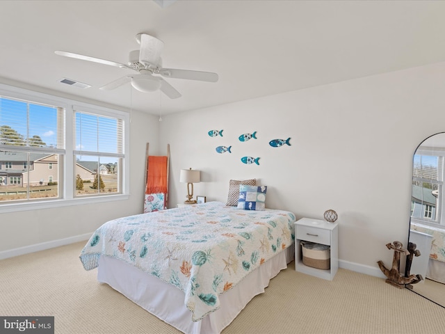 carpeted bedroom featuring a ceiling fan, visible vents, and baseboards