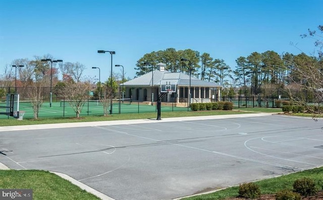 view of sport court with a tennis court, community basketball court, and fence