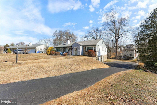 ranch-style house featuring a garage and a front lawn