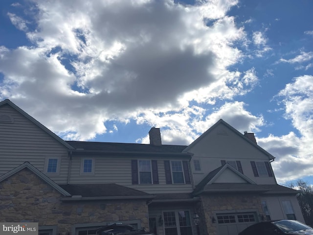 view of front of property featuring stone siding and a chimney