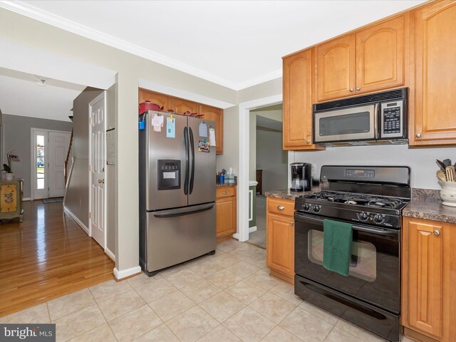 330 Mountaineers Way, Emmitsburg, MD 21727 - kitchen featuring appliances with stainless steel finishes, crown molding, dark countertops, light tile patterned floors, and baseboards