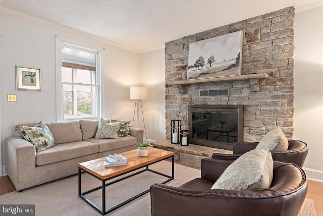 living area featuring visible vents, crown molding, wood finished floors, a fireplace, and baseboards