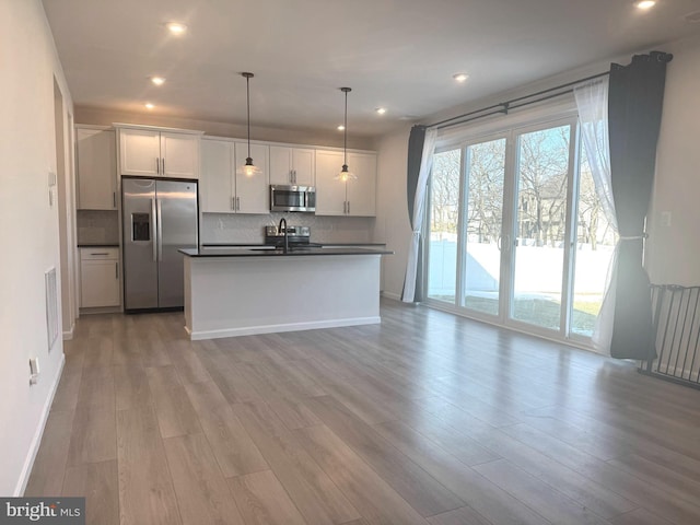 kitchen featuring stainless steel appliances, white cabinetry, hanging light fixtures, and sink