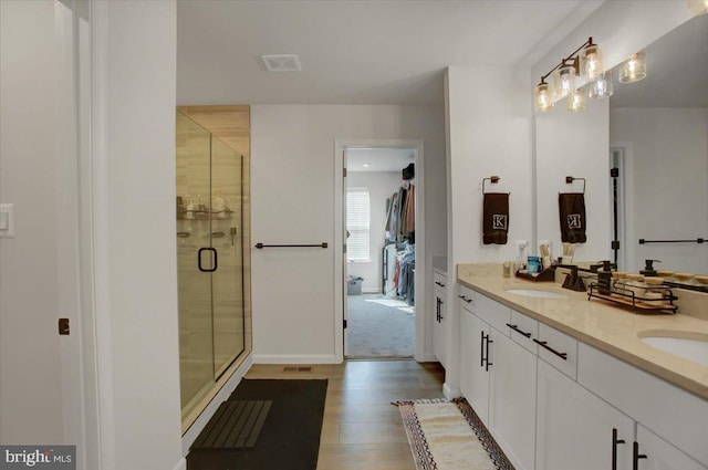 bathroom featuring vanity, hardwood / wood-style flooring, and a shower with door