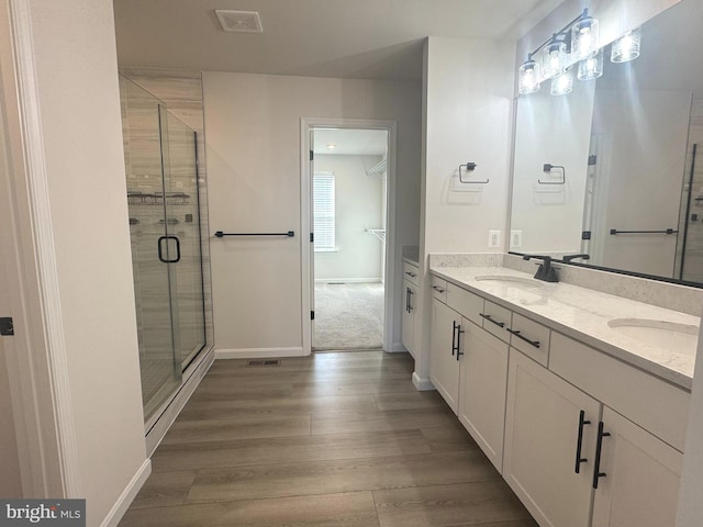 bathroom with vanity, hardwood / wood-style floors, and walk in shower