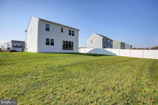 rear view of house featuring a lawn