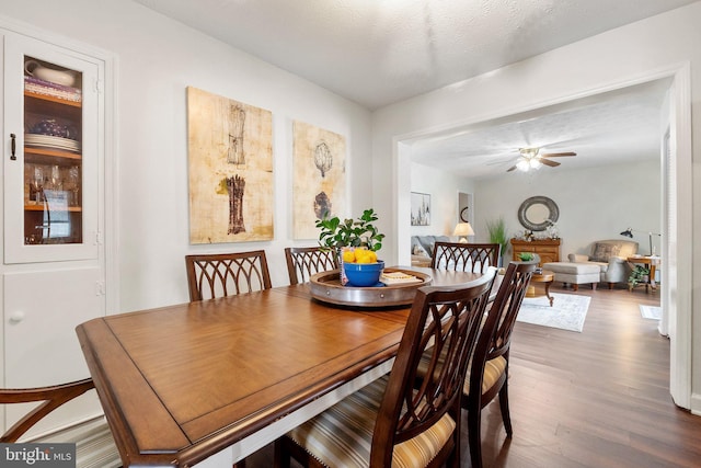 dining space with dark hardwood / wood-style floors and ceiling fan