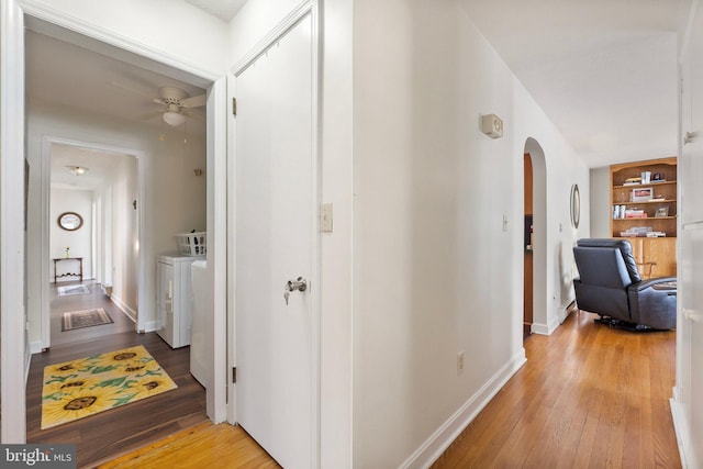 hallway with independent washer and dryer and light hardwood / wood-style floors