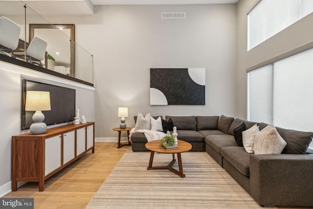 living room featuring light hardwood / wood-style floors and a high ceiling