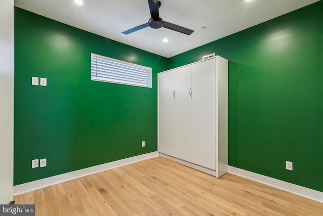 unfurnished bedroom featuring ceiling fan, light wood-type flooring, and a closet