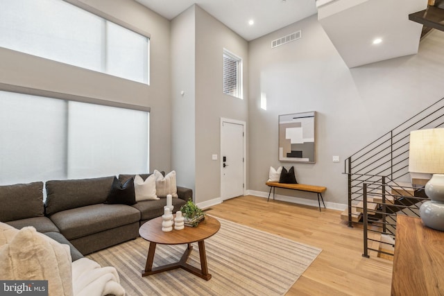 living room featuring a high ceiling and light wood-type flooring