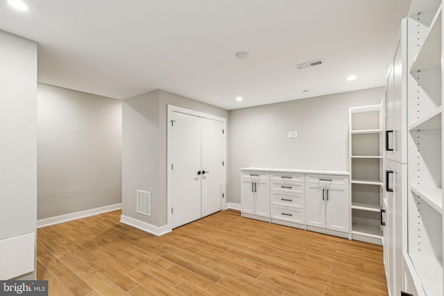 interior space with white cabinetry and light hardwood / wood-style flooring