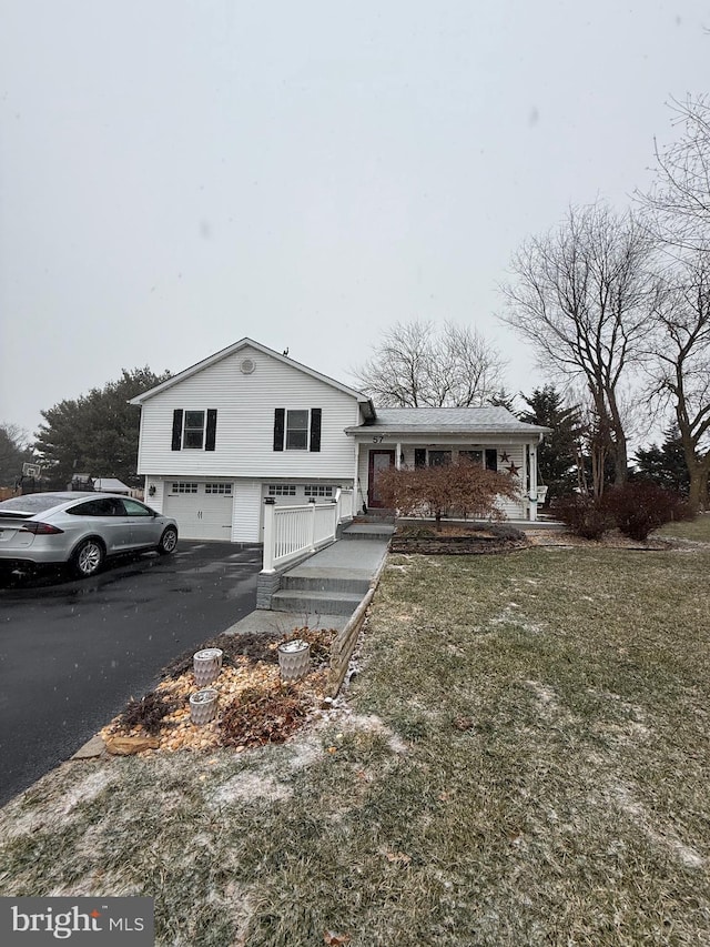 split level home with a garage and a front lawn