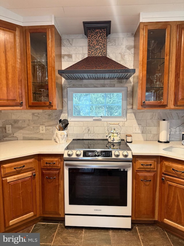 kitchen featuring tasteful backsplash, sink, range with electric stovetop, and custom exhaust hood