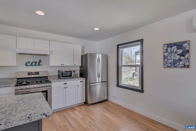 kitchen featuring white cabinetry, stainless steel appliances, light stone countertops, and light hardwood / wood-style floors