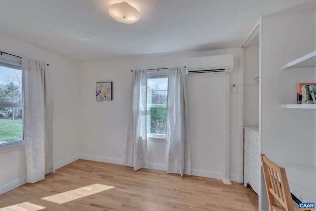 interior space with light hardwood / wood-style floors and an AC wall unit